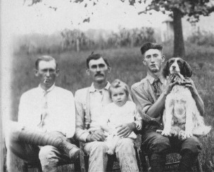 John Henry Eaton holding Gracie. Willie is to the right with the dog. The person on the left is unknown.